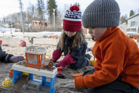 Lapset leikkivät hiekkalaatikolla.