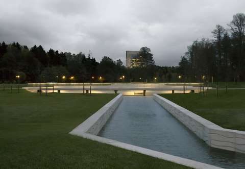 Kuvassa on Leimuniityn kanava ja kanavan ylittävä kevyen liikenteen silta iltavalaistuksineen. Kuva on otettu hämäränä aikana ja sillalla sekä taustalla näkyy valaisimia. Taustalla näkyy Accountor Tower.