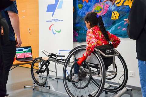 Lapsi pelaamassa digitaalisella ratakelaussimulaattorilla.