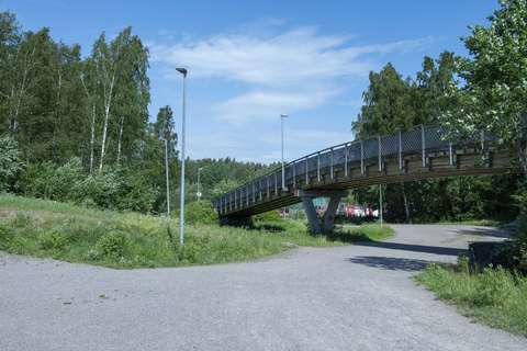 Kuvassa näkyy ulkoilureitin yli menevä hiihtosilta. Kuva on otettu kesällä.