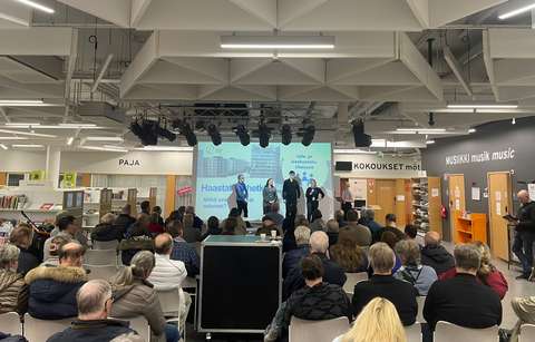 Yleisöä ja puhujia Ison Ison omenan kirjaston stagella.