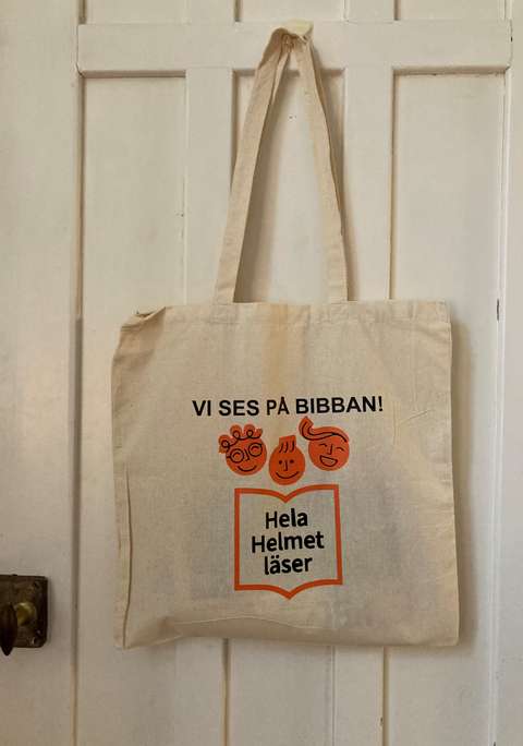 Kasse med texteb Vi ses på bibban och logon för projektet Hela Helmet läser