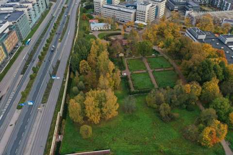Till vänster finns en stor väg med en park på höger sida. I bakgrunden syns höga byggnader.