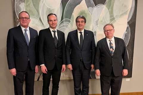 Neljä miestä seisoo maalauksen edessä.