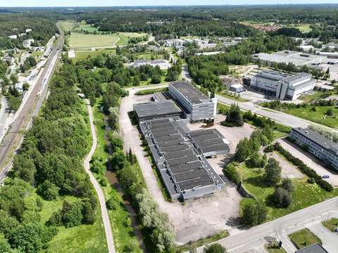 Ilmakuva Lasihytin alueesta. Keskellä kuvaa näkyy iso rakennus, jonka ympärillä on pienempiä rakennuksia ja puita. Rakennuksen vasemmalla puolella virtaa Espoonjoki. Kuvan vasemmassa reunassa kulkee junaraiteet.