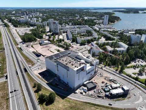 Byggnader, vägar, ett sandfält och havet i bakgrunden.