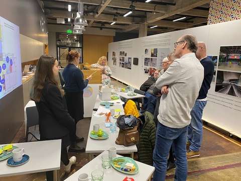 KAMUn vapaaehtoiset ovat seisten pöydän ympärillä keskustelemassa näyttelyistä.