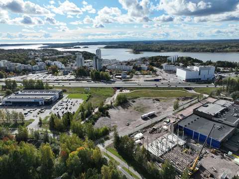 Ilmakuva Kiviruukista. Kuvan etualalla näkyy puita, matalia rakennuksia ja rakentamatonta maata. Taka-alalla näkyy Länsiväylä, Kivenlahti ja merta.