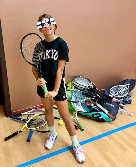 Tyttö tennismaila kädessä