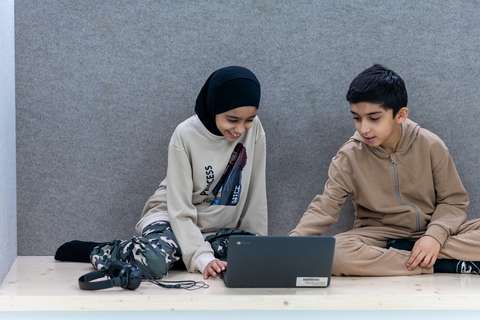 Kaksi oppilasta kannettavan tietokoneen äärellä opiskelemassa. 