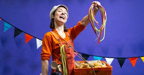 Sirkustaiteilija pitelee kädessään metrilakuja. 