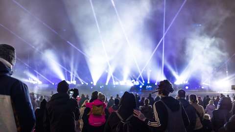 Ihmisiä katsomassa lasershowta uudenvuoden tapahtumassa.
