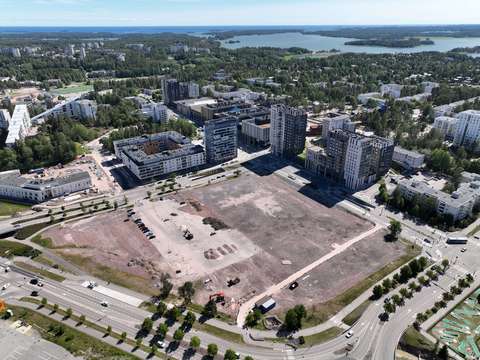 Aerial view of Espoonlahti. A large undeveloped area is visible in the foreground. The Lippulaiva shopping center is visible in the background.