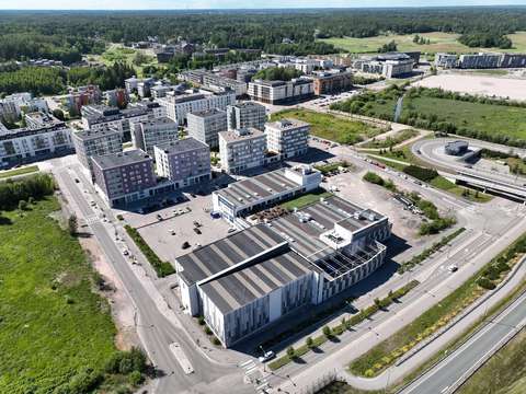 Aerial view of Suurpelto. The Suuris shopping center is visible in the foreground and residential apartment buildings are visible in the background.