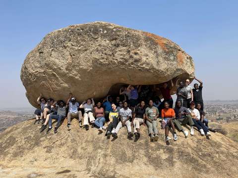 Ryhmä nuoria kiven alla.