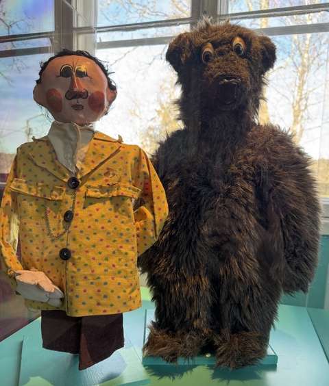 The puppet of the play the Bear that did not exist, the bear and the factory manager in a yellow suit.