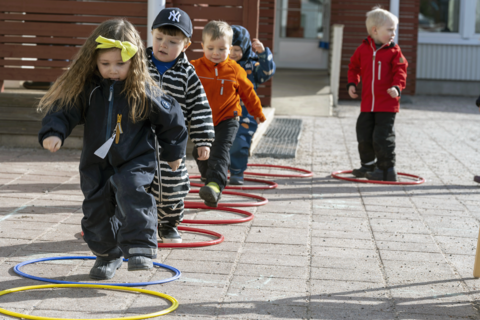 Lapset liikkuvat temppuradalla ulkona.