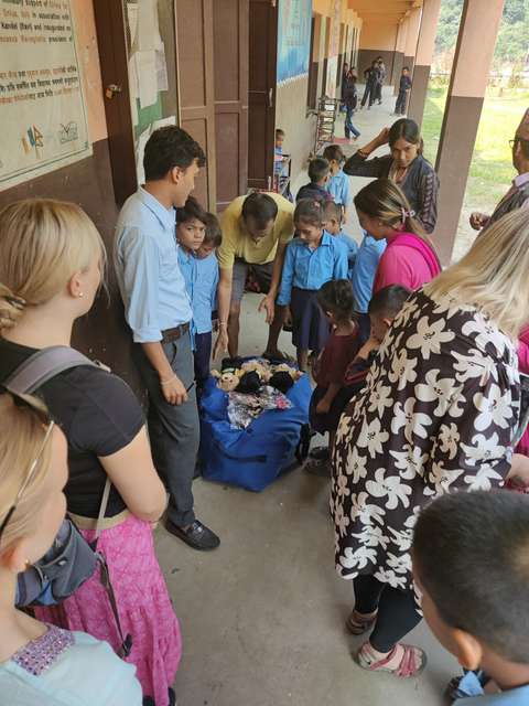 Människor tittar ner i en väska med gosedjur ovanpå.