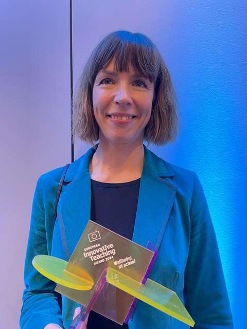 Nainen palkint kädessä.