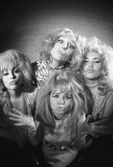 Fyra kvinnor med tokiga ansiktsuttrycken i en bild i svart och vitt.