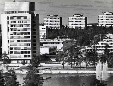 Mustavalkoisessa valokuvassa näkyy korkeita kerrostaloja ja puita sekä etualalla suuri vesiallas ja suihkulähde.