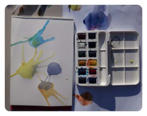 Vesiväripaletti sekä maalaus jossa erivärisiä läiskiä.