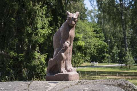 Ilves ja pentu -teos, metsä taustalla.