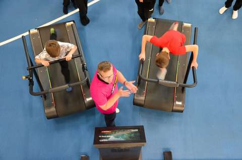 Kaksi nuorta pelaamassa liikuntapelejä juoksumatoilla.