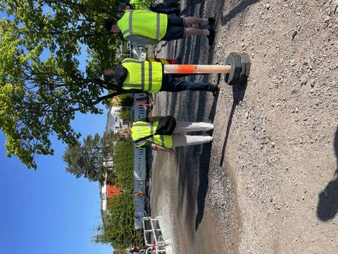 Henkilöitä huomiovaatteissa katuryömaalla.