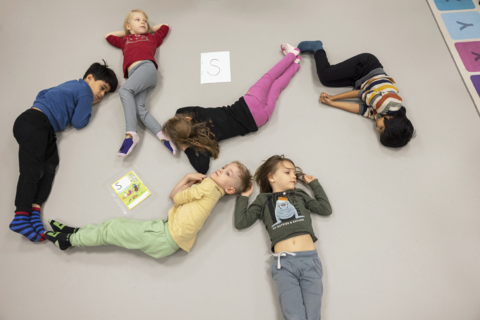 Lapset opettelevat S-kirjainta toiminnallisesti muodostamalla S-kirjaimen lattialle.