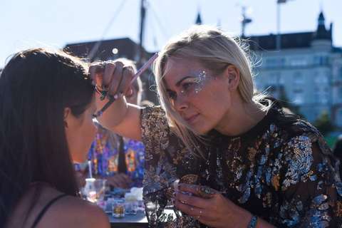 Kuvassa meikkaaja meikkaa lasta.