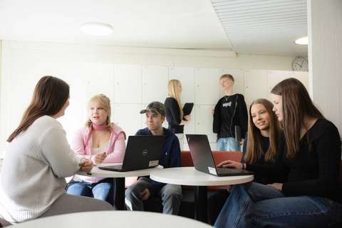 7 lukiolaista istumassa ja seisomassa.