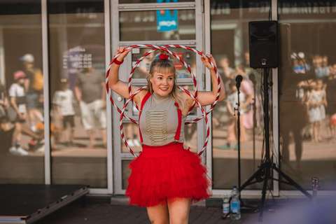 Esiintyjä pitelemässä käsissään hula-hula-vanteita ja hymyilemässä yleisölle.