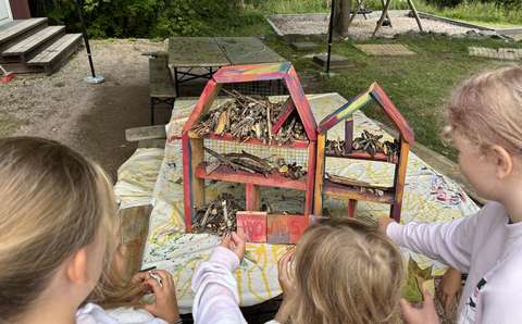 Lapsia hyönteishotellin edessä.