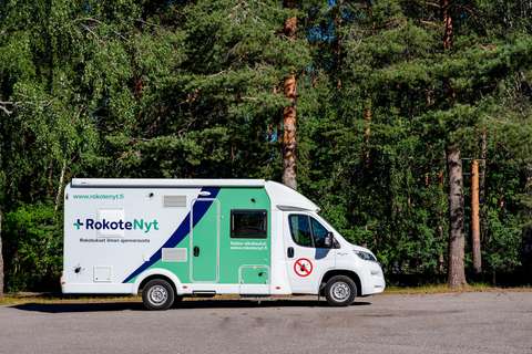 RokoteNyt bussi pysäköitynä metsän reunalle.