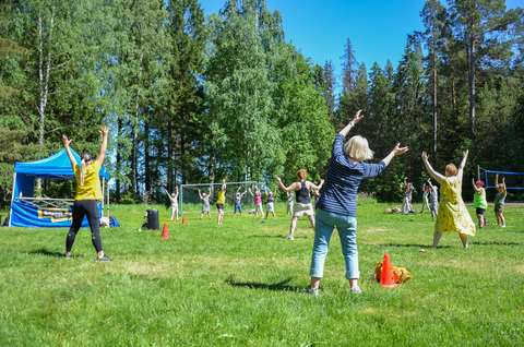 Vuxna som gympar på en äng.