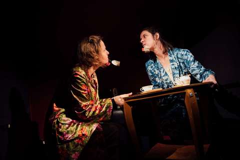 Kaksi vihaisen näköistä henkilöä pöydän ääressä.