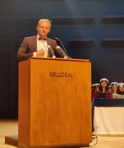 Rolle Rantaniemi, a graduate from 2014, at the podium.