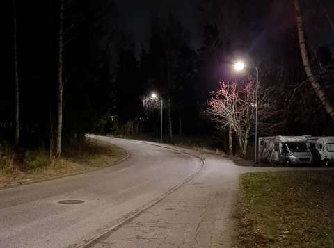 Kaksi katuvaloa palaa pimeässä illassa.