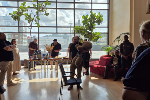 Koulutuspäivän osallistujat katsovat, kun kouluttaja esittelee turvavälineen käyttöä.