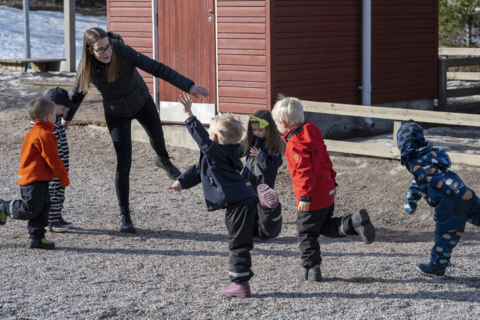 En barngrupp balanserar under lärarens ledning.