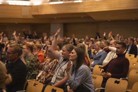 People who have raised their hands in the audience.