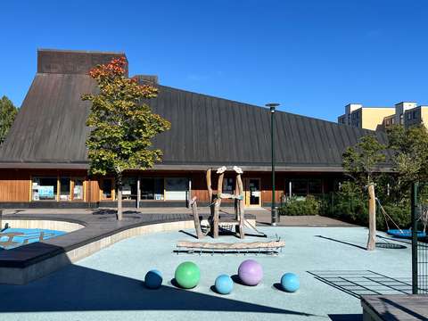 Kuvan taustalla Suvelan asukaspuisto ja etualalla leikkivälineitä.