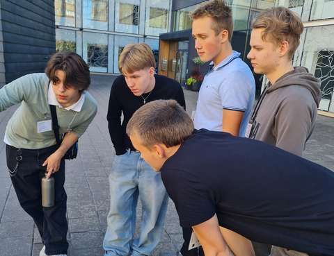 viisi poikaa tekee rastitehtävää ulkona