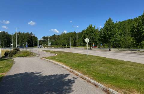  Picture of the planning area in its current state. In the foreground, the pavement on the south side of Höyrylaivantie and the road’s carriageway. In the background, the wooded planning area in its current state.