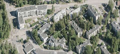 På flygbilden syns planområdet med tre trevåningshus.