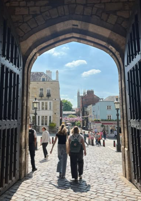 Portti Englannissa ja opiskelijoita portin sisällä.