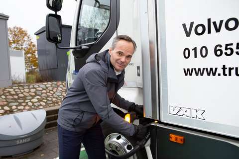 Kaupunginjohtaja Kai Mykkänen laittamassa sähköistä kuorma-autoa lataukseen