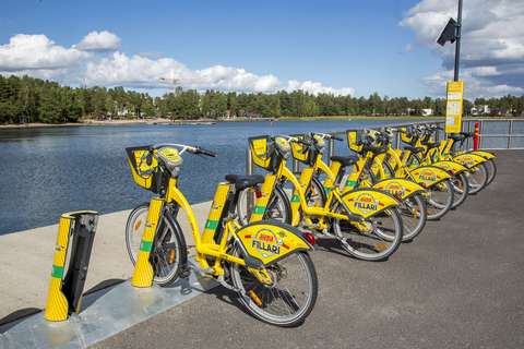 Gula stadscyklar i cykelparkeringen vid havet.