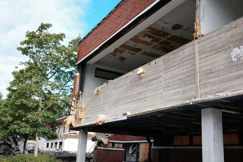 Punatiilinen rakennus, josta on purettu tiiliseinää.